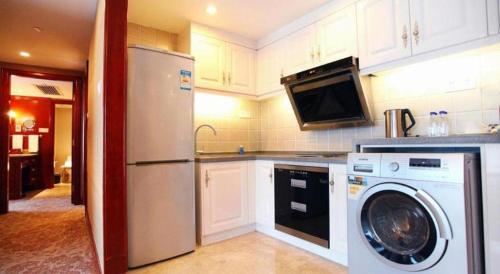 a kitchen with a refrigerator and a washing machine at Xiamen Jingmin Central Hotel in Xiamen