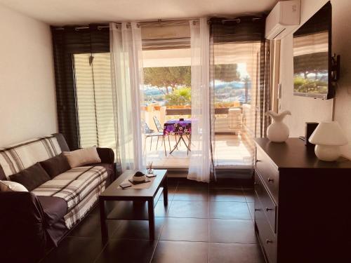 un salon avec un canapé et une table dans l'établissement Village naturiste Cap D Agde T2 Port Nature 5 coursives avec parking, au Cap d'Agde