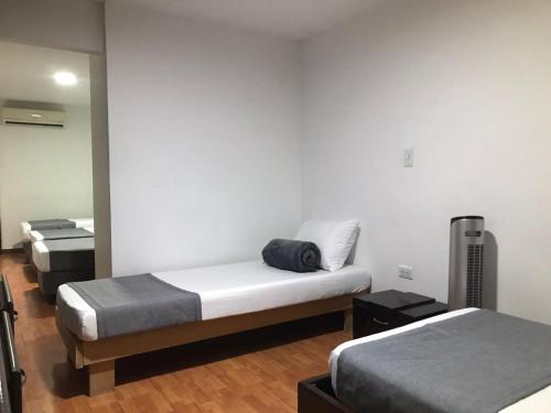 a room with two beds and a mirror at Hotel Castellon Plaza Pereira in Pereira