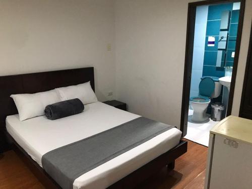 a bedroom with a bed and a bathroom with a toilet at Hotel Castellon Plaza Pereira in Pereira