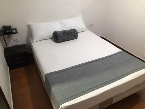 a bed with a black bag sitting on top of it at Hotel Castellon Plaza Pereira in Pereira
