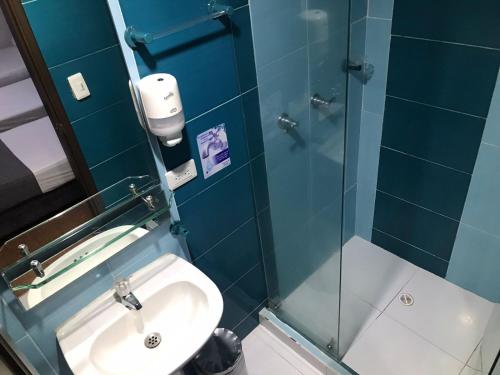 a bathroom with a sink and a glass shower at Hotel Castellon Plaza Pereira in Pereira