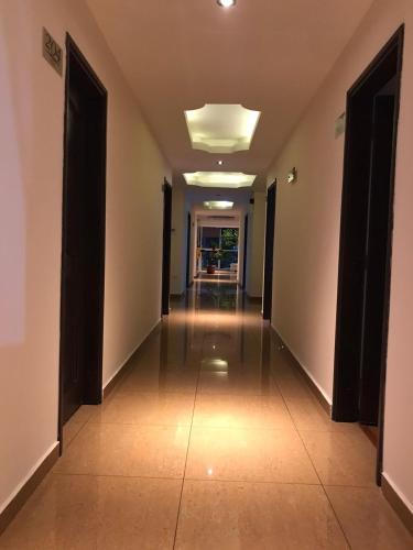 an empty hallway with doors and a tile floor at Hotel Castellon Plaza Pereira in Pereira
