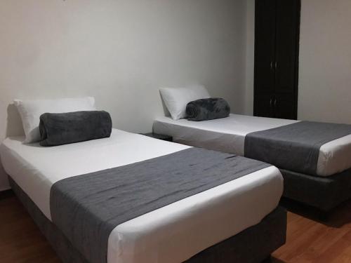 two beds in a hotel room with two bags on them at Hotel Castellon Plaza Pereira in Pereira