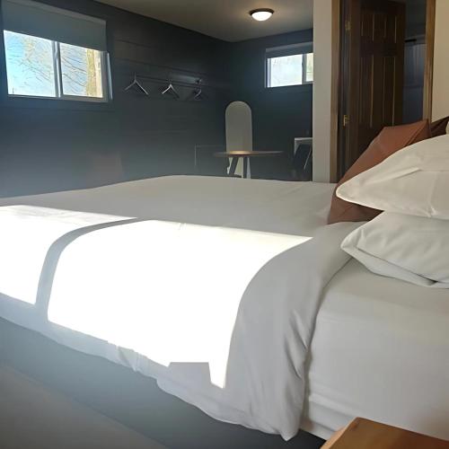 a bedroom with a bed with white sheets and pillows at Elk Antler Inn in Thermopolis