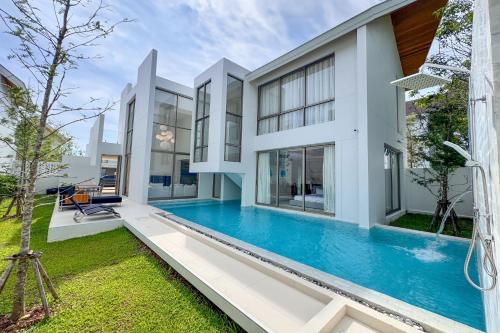 an exterior view of a house with a swimming pool at Designer 3BR Pool Villa in New Build LuxPride 4 L8 Residence in Bang Tao Beach