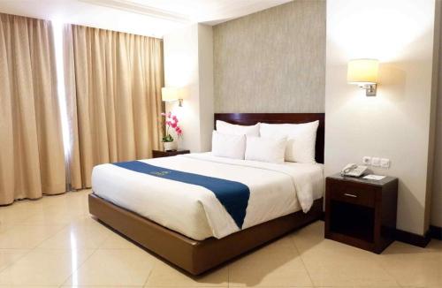 a bedroom with a large bed in a hotel room at Grage Hotel Cirebon in Cirebon