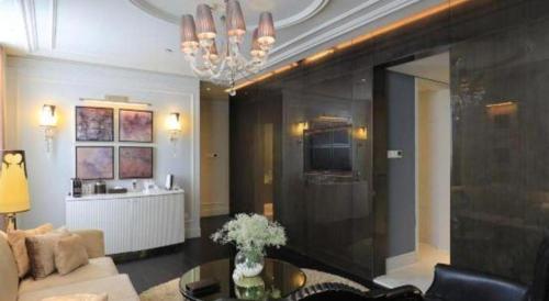 a living room with a couch and a chandelier at Jinjiang Metropolo Hotel Classiq Shanghai Off Bund in Shanghai