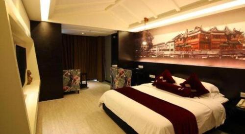 a bedroom with a bed and a painting on the wall at Grand Nest Hotel (Tang Jia Wan Beach) in Zhuhai