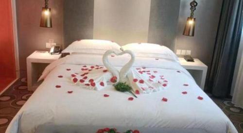 two swans making a heart shape on a bed with roses at Jinjiang Metropolo Hotel Classiq Shanghai Off Bund in Shanghai