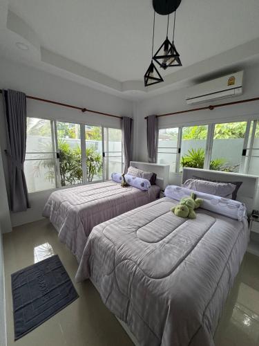 two beds in a bedroom with windows at Silver Palm Tree Villa - 2 Bedrooms Villa in Ao Nang Beach
