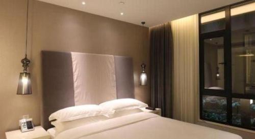 a bedroom with a white bed and a window at Jinjiang Metropolo Hotel Classiq Shanghai Off Bund in Shanghai