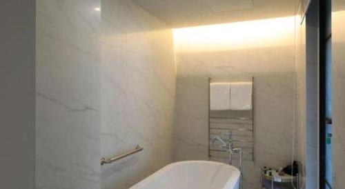 a white bathroom with a tub and a shower at Jinjiang Metropolo Hotel Classiq Shanghai Off Bund in Shanghai
