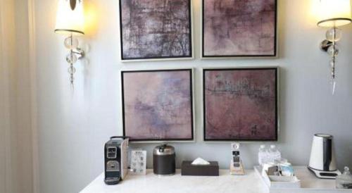 a room with four pictures on a wall with a counter at Jinjiang Metropolo Hotel Classiq Shanghai Off Bund in Shanghai
