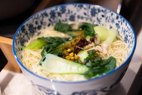 上海市にあるAtour X Hotel The Bund East Nanjing Roadの麺と野菜が入った青と白のボウル