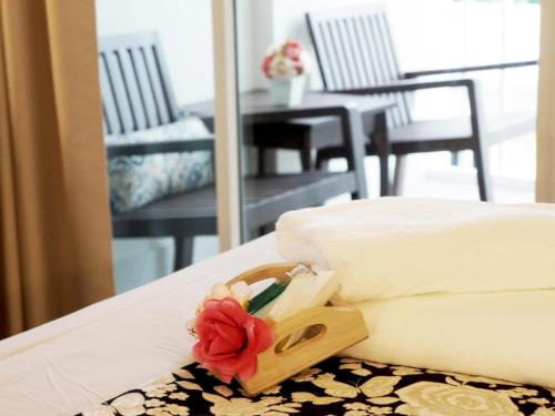 a close up of a bed with a flower on it at Baan Pimpisa in Pattaya Central