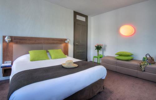 une chambre avec un grand lit avec des oreillers verts dans l'établissement Campanile Annecy Centre - Gare, à Annecy
