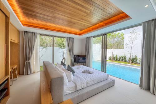 a bedroom with a large bed and a pool at Designer 3BR Pool Villa in New Build LuxPride 4 L8 Residence in Ban Pak Lak