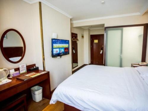 a bedroom with a white bed and a mirror at GreenTree Inn Luoyang Zhongzheng Street Express Hotel in Luoyang