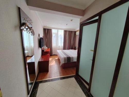 a hotel room with a bed and a mirror at GreenTree Inn Luoyang Zhongzheng Street Express Hotel in Luoyang