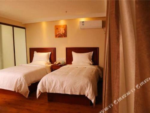 a bedroom with two beds with white sheets at GreenTree Inn Luoyang Zhongzheng Street Express Hotel in Luoyang