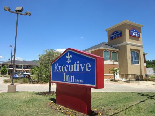 a blue executive inn sign in front of a building at Executive Inn and Suites Tyler in Tyler