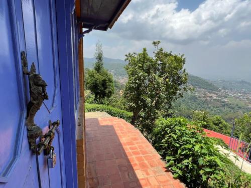 a blue door with a view of a brick walkway at Joy Source Resort in Kathmandu