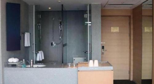 a large bathroom with a shower and a sink at New Century Kylie Hotel Ningbo in Ningbo