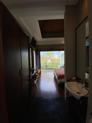 a bathroom with a sink and a bed in a room at Del Cielo Villa Jimbaran in Jimbaran