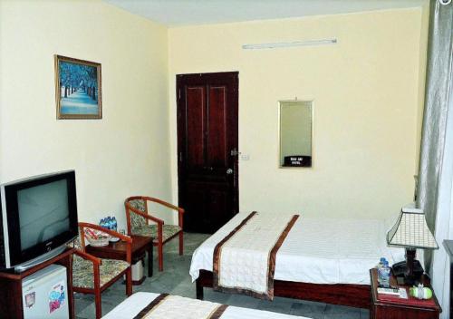 a hotel room with a bed and a tv and a bedroom at Hai Au Hotel in Hai Phong