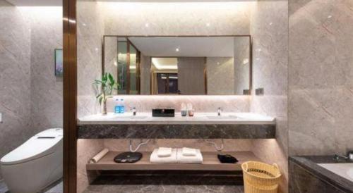 a bathroom with a sink and a toilet and a mirror at Rosedale Hotel Taicang in Taicang