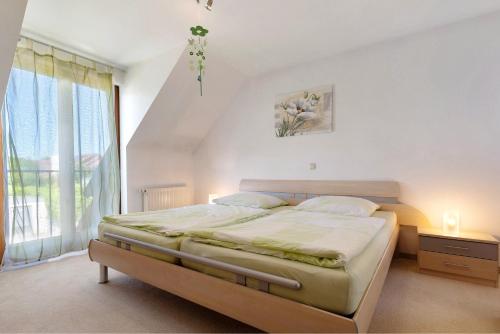 a bedroom with a bed and a large window at Ferienhaus am Mühlenbach, 110qm in Schwanau