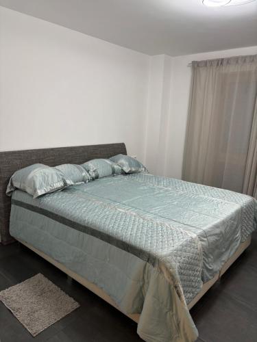 a bedroom with a bed with a blue comforter and pillows at Moderne Ferienwohnung Sonnenbühl in Singen