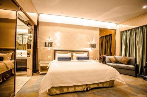 a large bedroom with a large bed and a couch at Shanghai Fuyue Hotel in Shanghai