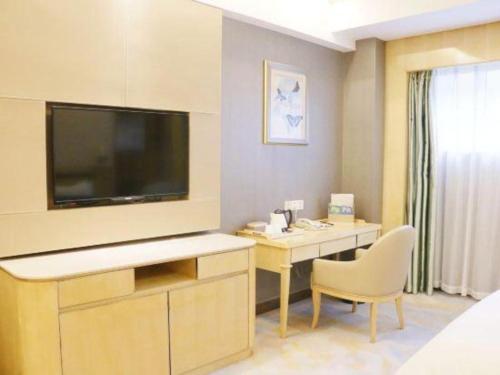 a hotel room with a desk with a large television at Shanghai Fuyue Hotel in Shanghai