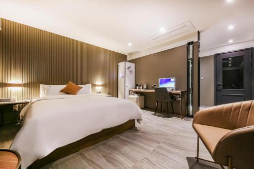 a bedroom with a bed and a desk with a computer at Cheongju Maryjane Hotel in Cheongju