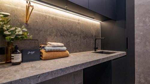 a kitchen with a sink and a counter with a bottle of wine at Peak Chalet in Mount Hotham
