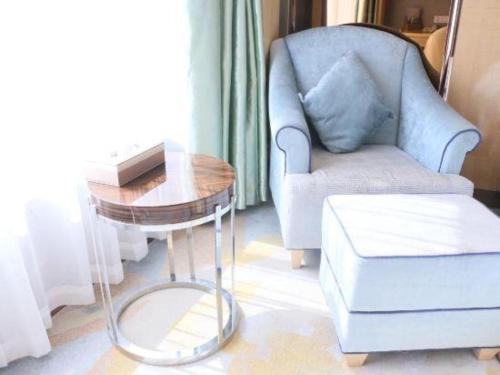 a living room with a chair and a table at Shanghai Fuyue Hotel in Shanghai