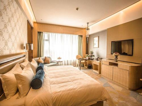 a bedroom with a large bed with a person laying on it at Shanghai Fuyue Hotel in Shanghai
