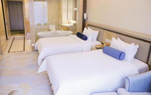 a hotel room with two beds and a bath tub at Shanghai Fuyue Hotel in Shanghai
