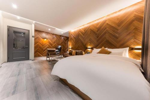 a hotel room with a large bed and a chair at Cheongju Maryjane Hotel in Cheongju