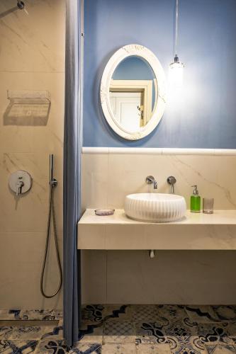 a bathroom with a sink and a mirror at Nafsika Suites in Nea Moudania