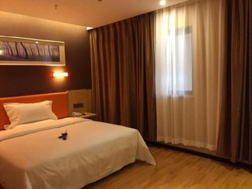 a bedroom with a large white bed and a window at 7 Days Premium Nanjing Gaochun Beiling Road Branch in Gaochun