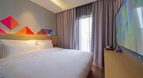 Postel nebo postele na pokoji v ubytování Borrman Hotel Zhaoqing Sihui Tianguangxu Jade City