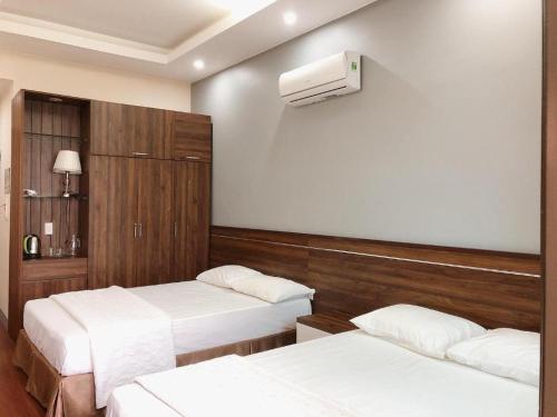 a hotel room with two beds and a air conditioner at Hon Ngu Hotel Cua Lo Beach in Cửa Lò
