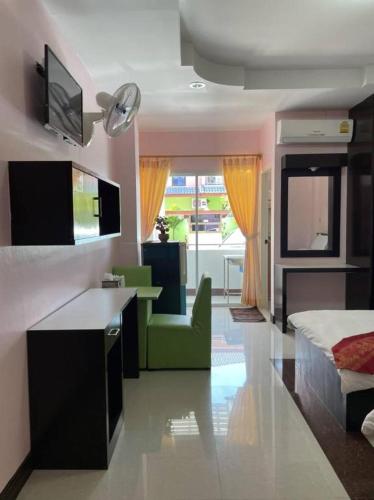 a bedroom with a bed and a living room with a couch at OYO 75399 Choktipparat Place in Udon Thani