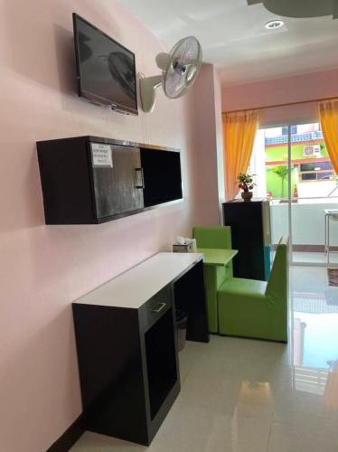 a room with a desk and a tv on the wall at OYO 75399 Choktipparat Place in Udon Thani