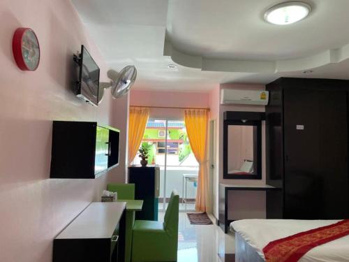 a room with a bedroom with a bed and a desk at OYO 75399 Choktipparat Place in Udon Thani