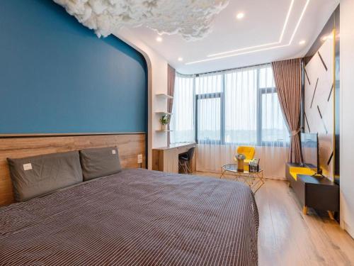 a bedroom with a large bed and a blue wall at Muse Hanoi Boutique Apartment - Hidden9 in Hanoi