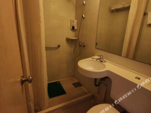 a bathroom with a sink and a toilet and a mirror at Jinjiang Inn Tianjin Station Jinwan Square in Tianjin